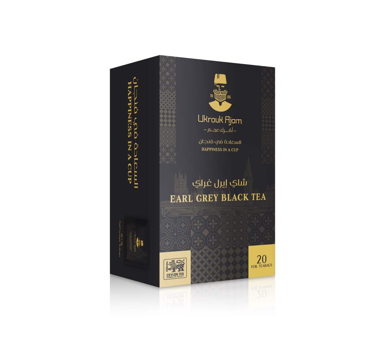 Ukrouk Ajam Earl Grey Black Tea in a luxurious black box of 20 foil teabags, featuring golden arabesque patterns and both Arabic and English branding, symbolizing 'Happiness in a Cup.
